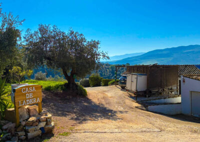 Einfahrt der Casa de Ladras mit Schild im Vordergrund und Parkraum im hinteren Bereich