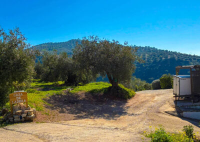 Einfahrt der Casa de Ladras mit Schild im Vordergrund und Parkraum im hinteren Bereich